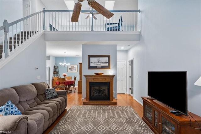 3702 Belfry Ct, Greensboro, NC 27410 - living room featuring a ceiling fan, wood finished floors, a towering ceiling, stairway, and a chandelier