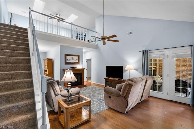 3702 Belfry Ct, Greensboro, NC 27410 - living room featuring a ceiling fan, stairway, a fireplace, wood finished floors, and high vaulted ceiling