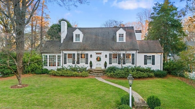 cape cod-style house featuring a front yard