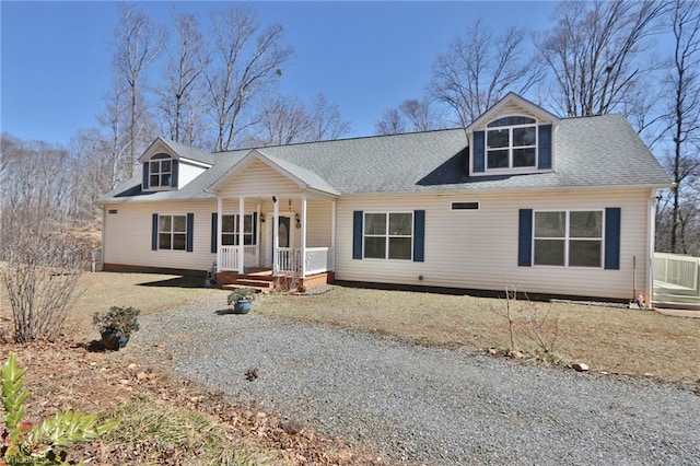 view of front facade featuring covered porch, driveway, and roof with shingles