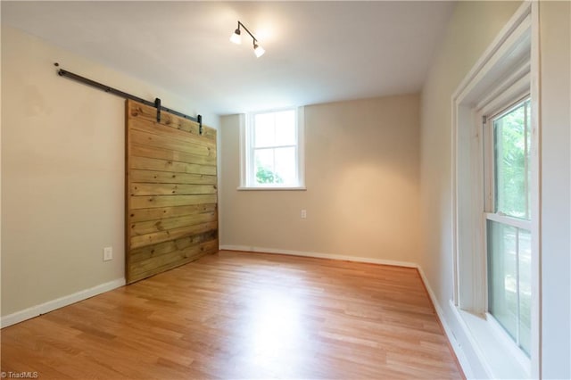 627 Mulberry St, Winston-Salem, NC 27101 - unfurnished room with plenty of natural light, a barn door, and wood finished floors