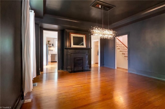 627 Mulberry St, Winston-Salem, NC 27101 - unfurnished living room featuring a chandelier, stairs, wood finished floors, a raised ceiling, and a fireplace with flush hearth