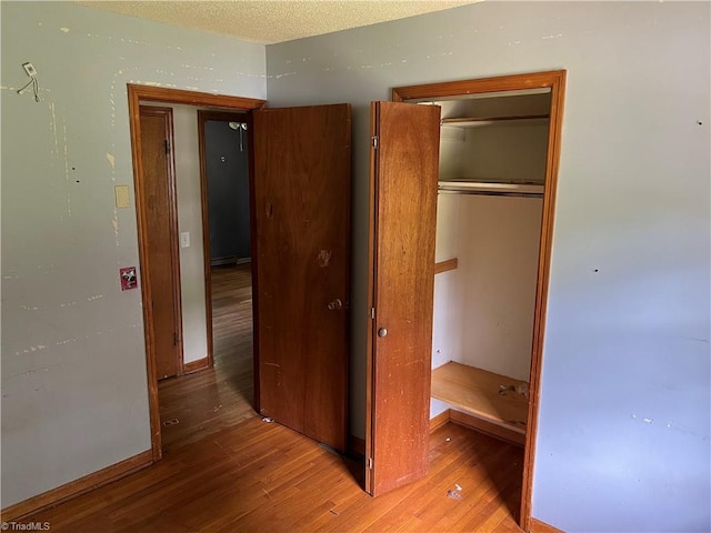 unfurnished bedroom featuring a closet and hardwood / wood-style flooring