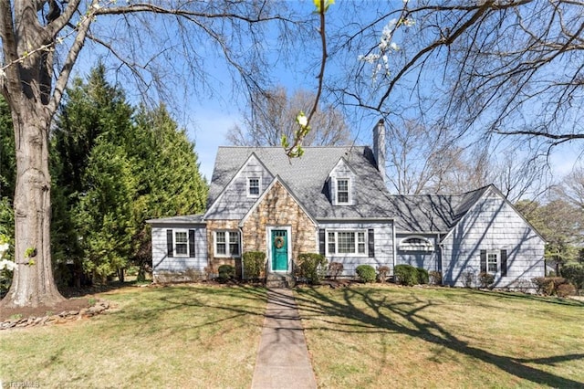 cape cod-style house featuring a front lawn, stone siding, and a chimney