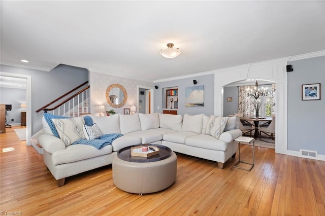 living area with stairs, light wood-type flooring, baseboards, and crown molding