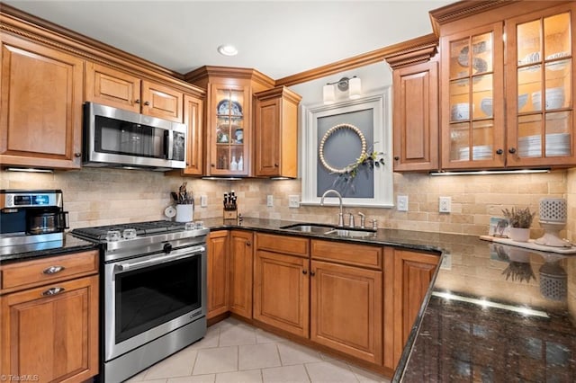 kitchen featuring brown cabinetry, stainless steel appliances, and a sink