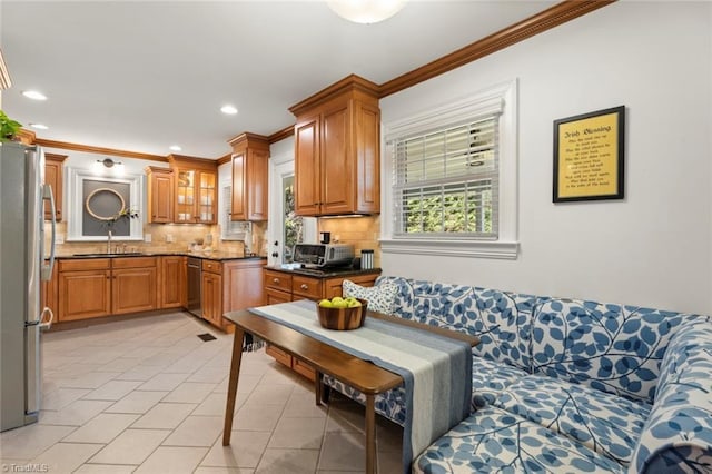 kitchen with a sink, stainless steel appliances, brown cabinets, and decorative backsplash