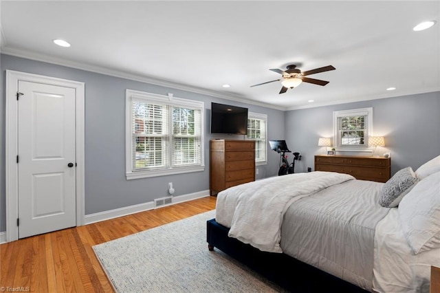 bedroom with crown molding, visible vents, baseboards, and light wood finished floors