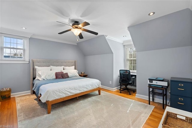 bedroom featuring crown molding, light wood-style floors, baseboards, and lofted ceiling