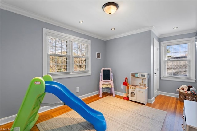 playroom with recessed lighting, crown molding, light wood-style floors, and baseboards