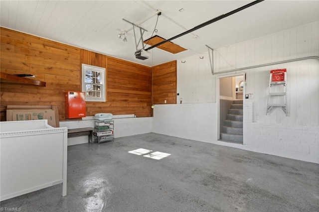 garage featuring a garage door opener and concrete block wall