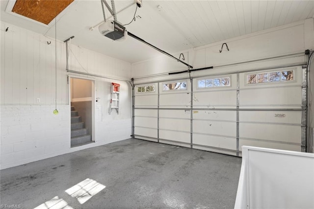 garage with concrete block wall and a garage door opener