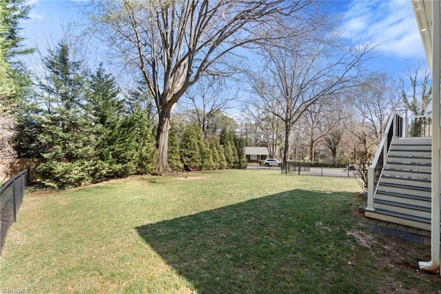 view of yard featuring stairs and a fenced backyard