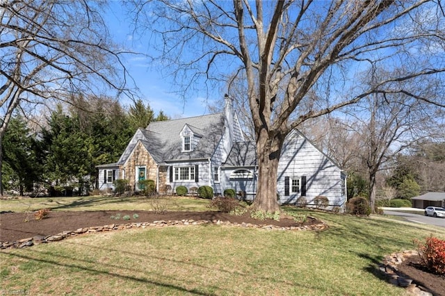 cape cod-style house featuring stone siding and a front yard