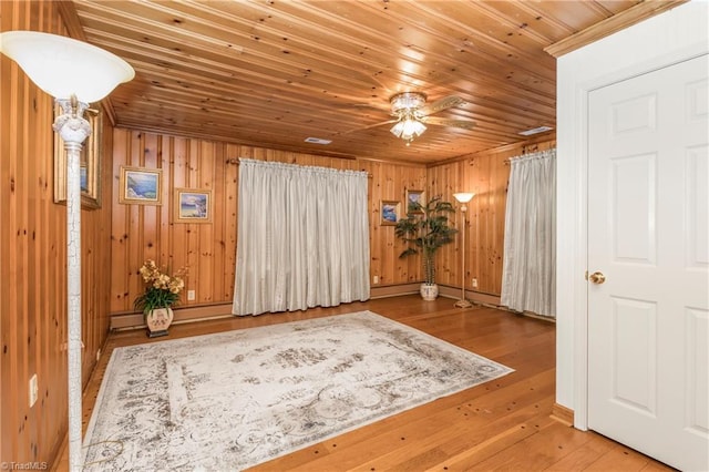 unfurnished room with wood-type flooring, wood ceiling, and wooden walls