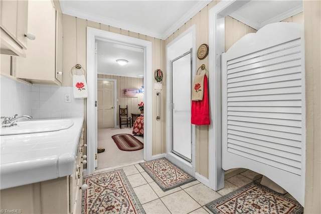 bathroom featuring tile patterned flooring, crown molding, and sink