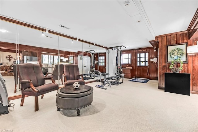 living room featuring light colored carpet, wooden walls, and crown molding