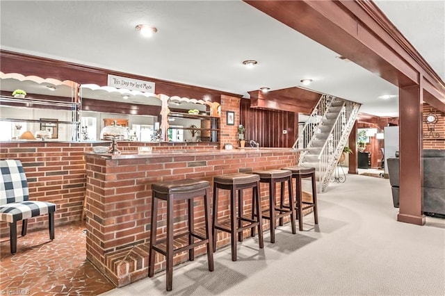 bar with ornamental molding, carpet, and brick wall