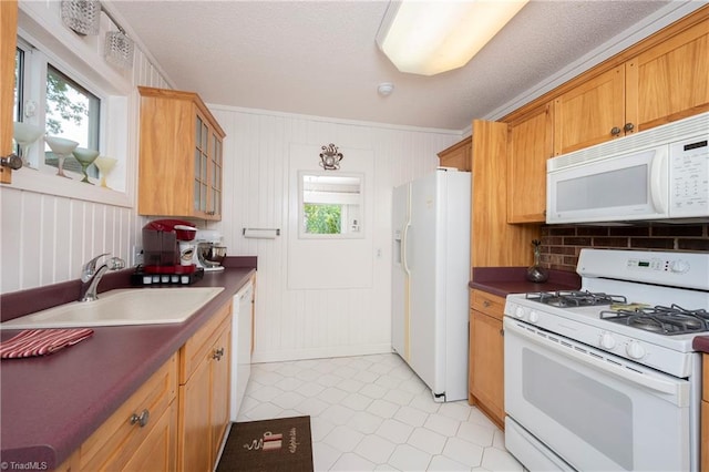 kitchen with plenty of natural light, sink, light tile patterned flooring, and white appliances