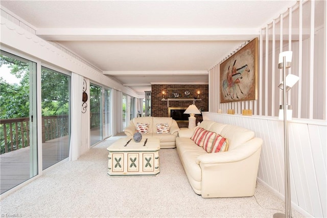 living room featuring brick wall, carpet, a brick fireplace, and beam ceiling