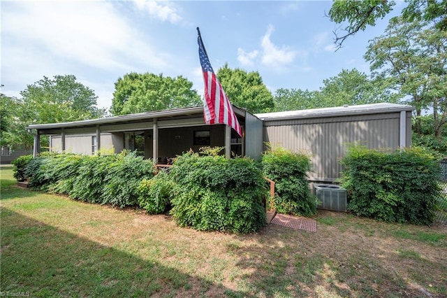 exterior space with central air condition unit and a lawn