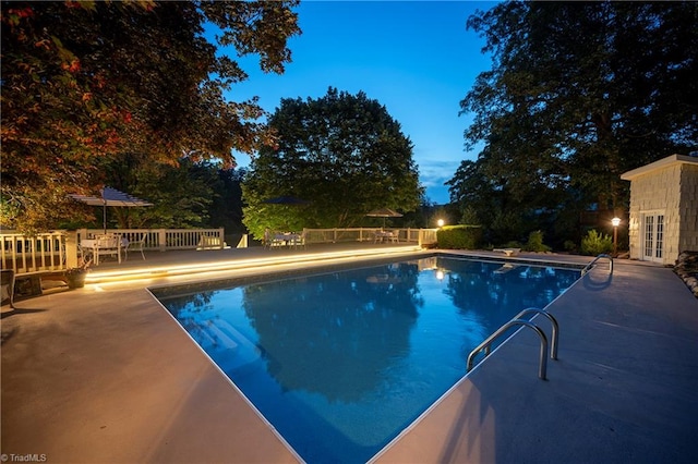 view of swimming pool featuring a patio area, french doors, and a diving board