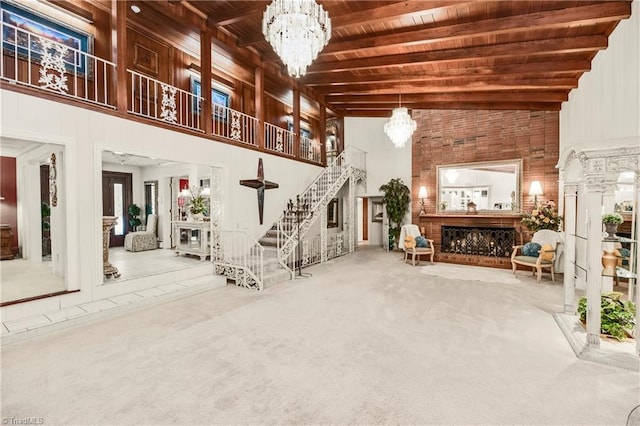 interior space featuring beam ceiling, carpet flooring, a chandelier, wooden ceiling, and high vaulted ceiling