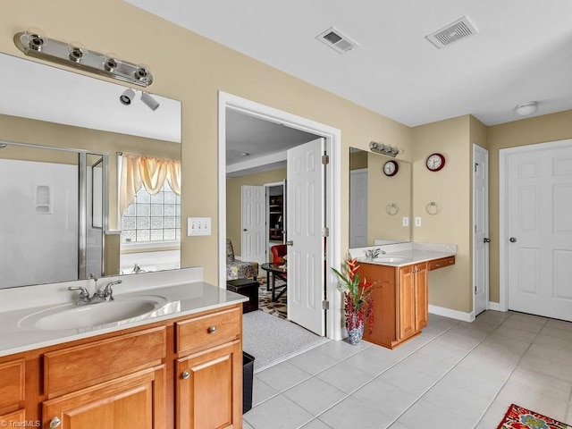 bathroom featuring vanity, a shower with shower door, and tile patterned floors