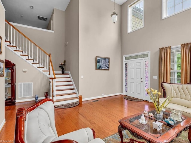 living room with hardwood / wood-style flooring and a towering ceiling