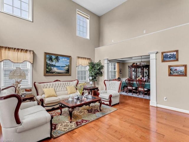 living room featuring an inviting chandelier, a high ceiling, and light wood-type flooring