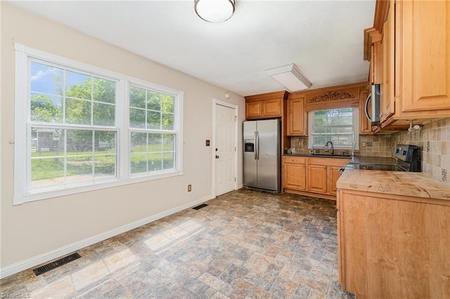 kitchen with visible vents, stone finish floor, plenty of natural light, and stainless steel appliances