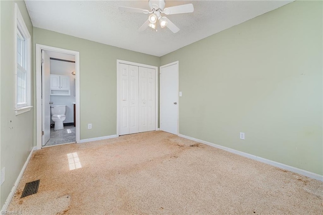 unfurnished bedroom with visible vents, baseboards, a closet, carpet, and connected bathroom