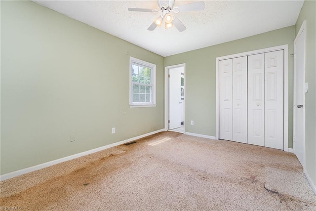 unfurnished bedroom featuring a closet, baseboards, visible vents, a ceiling fan, and carpet floors