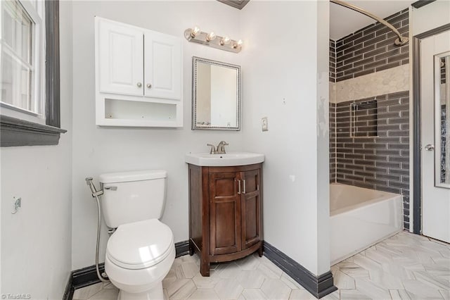bathroom featuring toilet, vanity, and baseboards