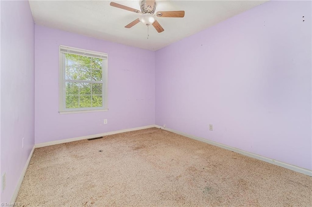 carpeted empty room with ceiling fan, baseboards, and visible vents