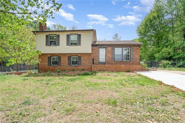 split level home with fence and a front lawn