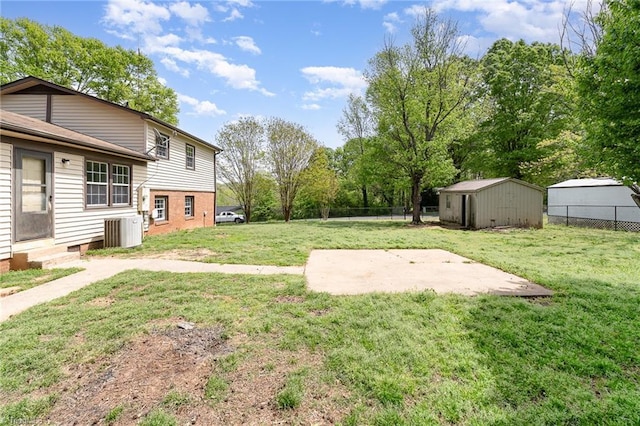 view of yard featuring entry steps, a storage shed, an outdoor structure, and fence