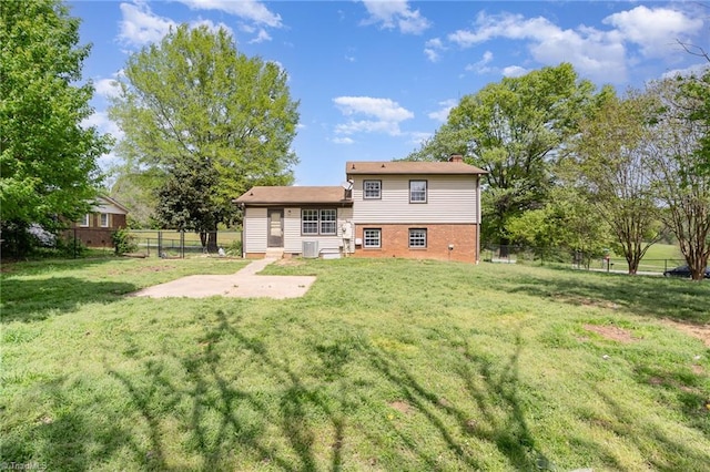 back of property with a patio area, a fenced backyard, a lawn, and a chimney
