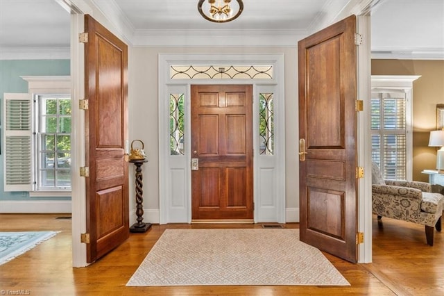 entryway with light hardwood / wood-style floors and ornamental molding