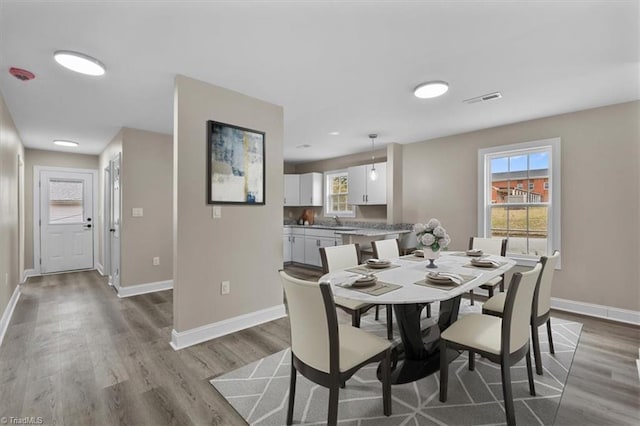 dining room with wood finished floors, baseboards, and visible vents