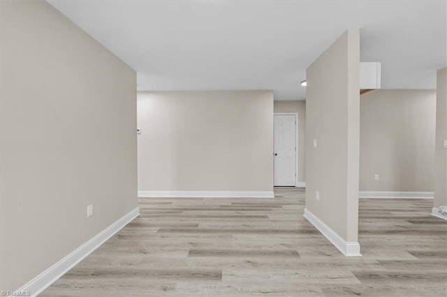 spare room featuring light wood-type flooring and baseboards