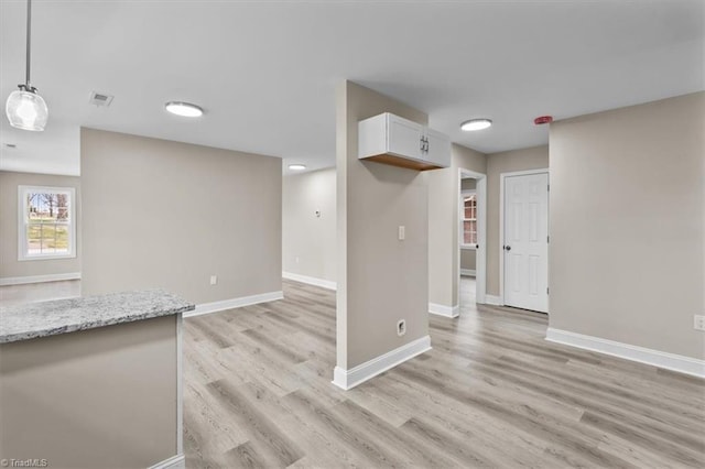 unfurnished room featuring visible vents, baseboards, and light wood-type flooring