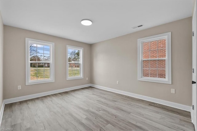 empty room with visible vents, baseboards, and wood finished floors