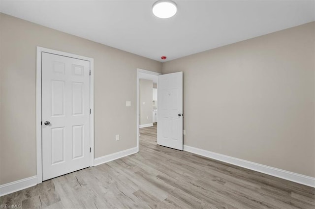 unfurnished bedroom with baseboards and wood finished floors