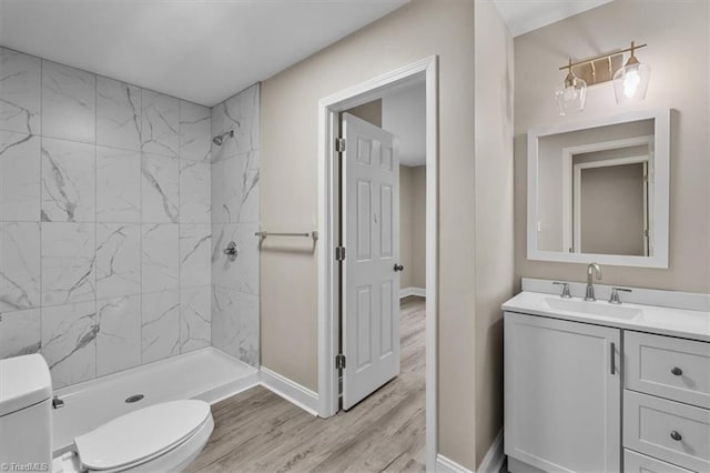 full bathroom featuring vanity, wood finished floors, baseboards, a shower stall, and toilet