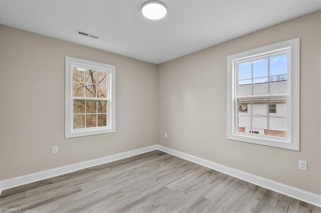 empty room with plenty of natural light, baseboards, and visible vents