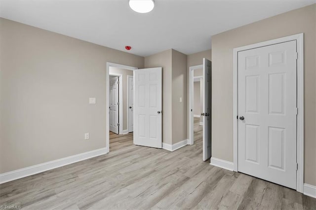 unfurnished bedroom featuring baseboards and light wood-style flooring