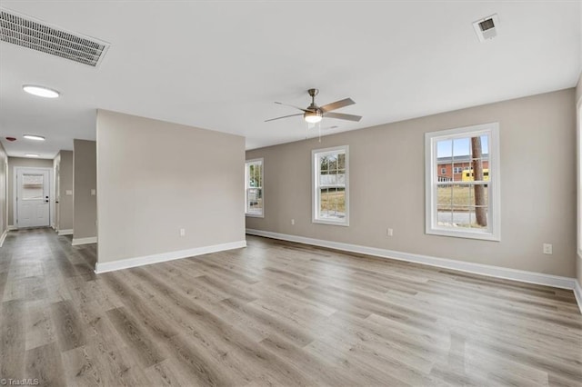 unfurnished room featuring visible vents, baseboards, and light wood finished floors