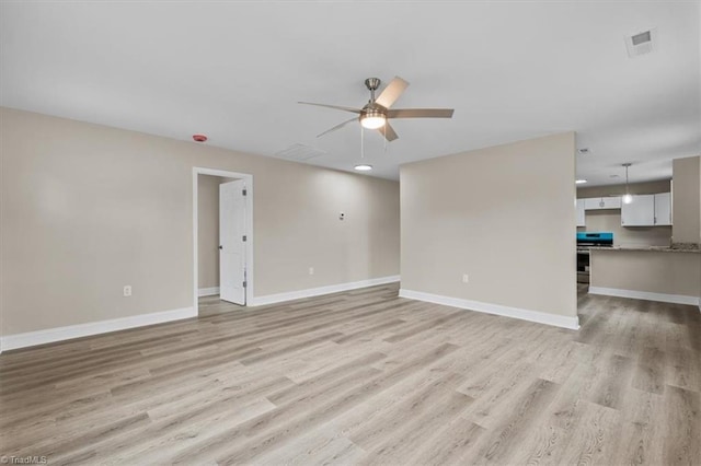 unfurnished living room with baseboards, visible vents, and light wood finished floors