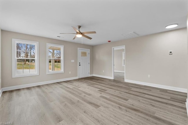 unfurnished living room featuring a ceiling fan, visible vents, baseboards, and light wood finished floors